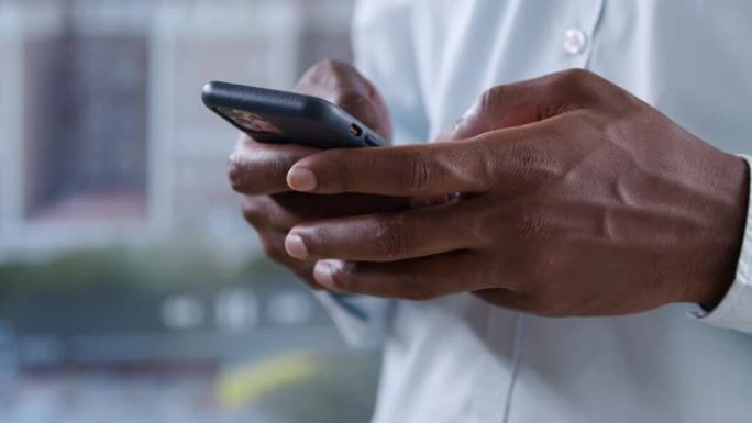 一个黑人男子的手在智能手机屏幕上翻阅新闻提要的特写镜头