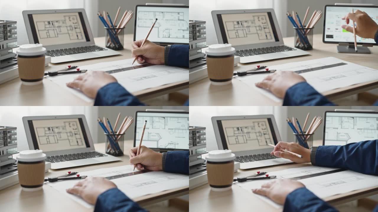 特写建筑师绘图使用铅笔与笔记本电脑和建筑平面图一起工作