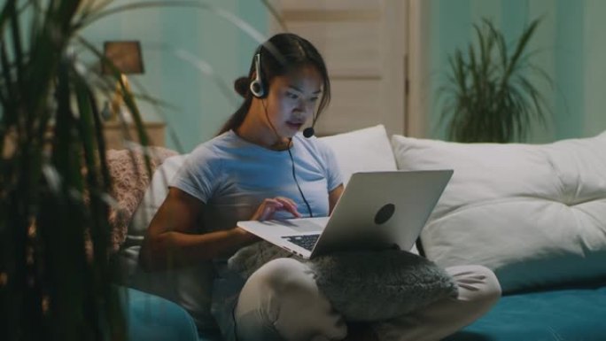 客厅使用笔记本电脑的亚洲女性