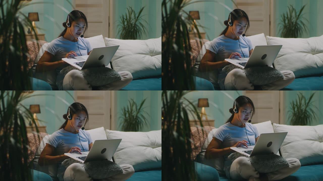 客厅使用笔记本电脑的亚洲女性