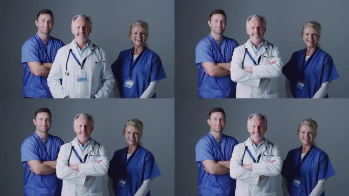 工作室肖像，三名外科团队成员穿着磨砂站在灰色背景下
