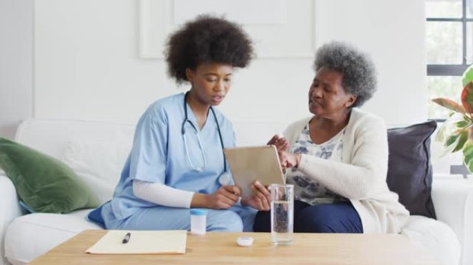 非裔美国女医生和高级女性说话和使用平板电脑