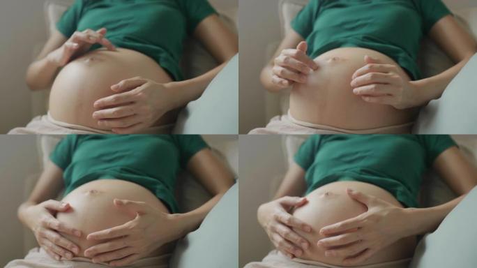 孕妇的特写镜头期待母亲抚摸怀孕的肚子。
