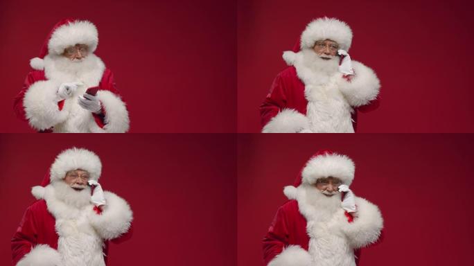 一个开朗的圣诞老人在红色智能手机上打电话给某人，站在红色背景上，有一个链接的地方