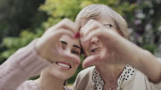 母女俩摆姿势拍照的4k录像用手做成心形