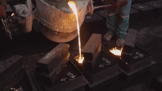 工厂工人在铸钢铸造厂将熔融金属倒入铸件的特写镜头