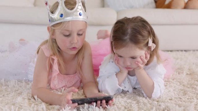 学习，电话和孩子们在他们房子的客厅地板上播放有关技术的视频。在家里的地毯上，为姐姐，女孩或孩子提供有