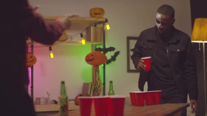 黑人在万圣节派对上玩啤酒乒乓球