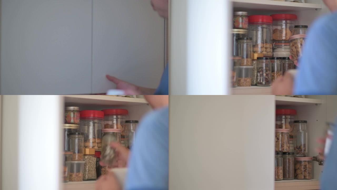 亚洲中国男性从厨房的架子柜里取回食品瓶