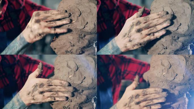艺术家手触摸泥塑的特写