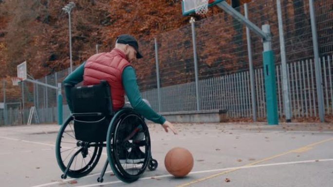 坐在轮椅上的男子在篮球场上运球