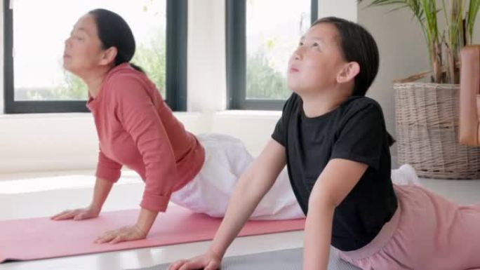 健身，家庭和亚洲瑜伽由母亲和女儿在地板上锻炼，冥想和健康锻炼在家庭普拉提中，女孩和妈妈训练，放松与和