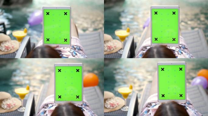 女人躺在游泳池上使用数字平板电脑绿屏