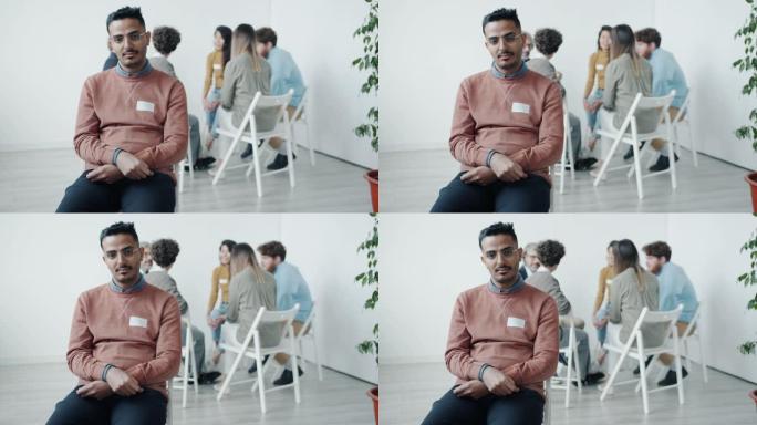 坐在集体治疗会议上不快乐的中东男子的慢动作肖像