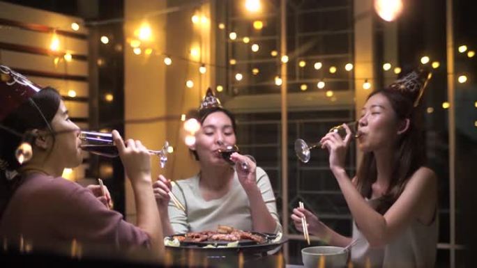 亚洲女性朋友一起在新年派对上玩得开心，在家喝葡萄酒
