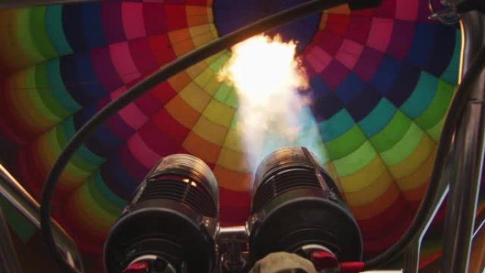 慢动作近距离观察飞行前正在充气的彩色热气球内部的火焰。