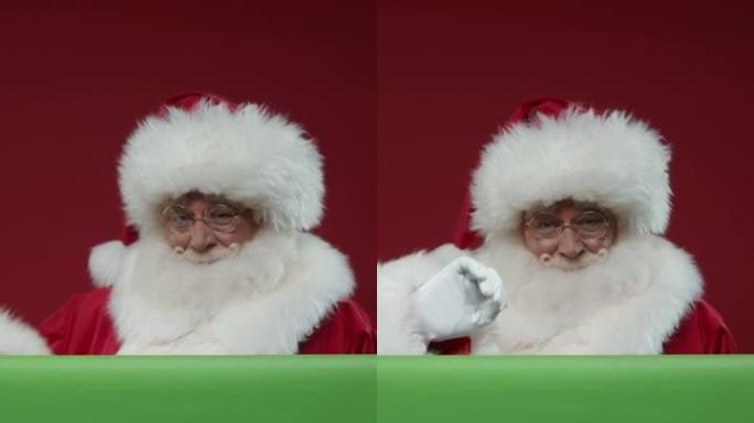 一个微笑的圣诞老人在绿色屏幕后面的红色背景上走进框架的垂直视频，对着相机挥手，抚摸屏幕，然后走开