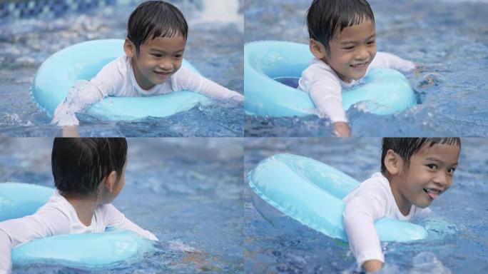用游泳圈游泳的亚洲小男孩。