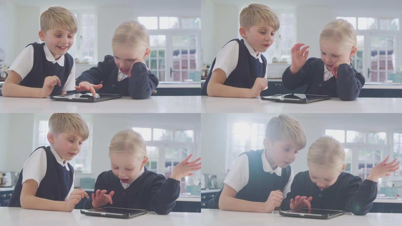 两个穿着校服的孩子在厨房里玩柜台上的数字平板电脑