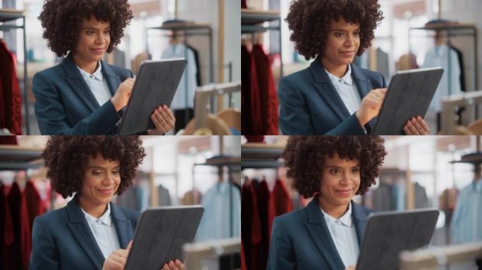 一位快乐的女性商品经理在时尚的服装店使用平板电脑的肖像。专业商店销售零售助理检查库存。小企业主订购商