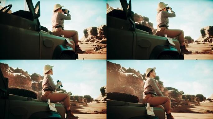 沙漠之旅: 美丽的女性旅行者坐在越野SUV的引擎盖上看着双筒望远镜，规划着充满惊奇和探索的路线。穿越