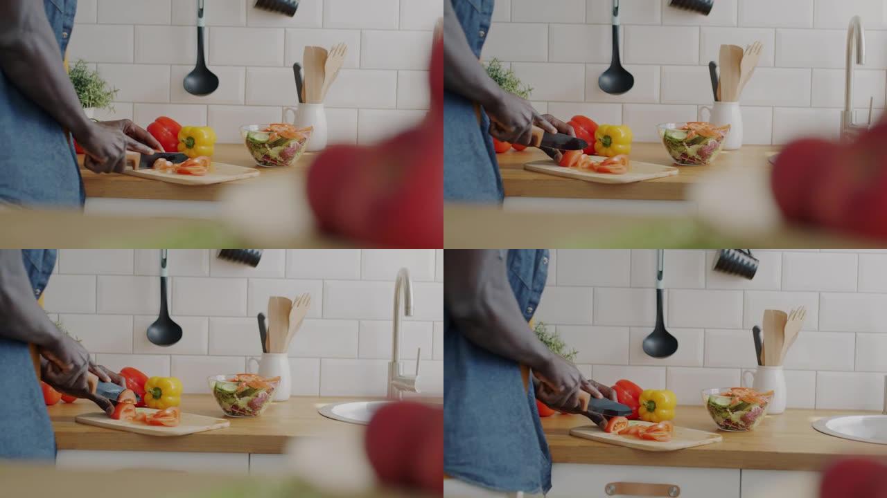 男性用刀手在现代房子的厨房里准备沙拉切菜