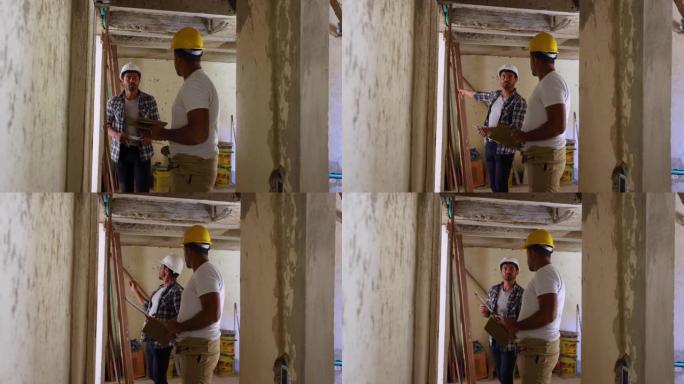 施工主管在加固墙壁时向非裔美国蓝领工人发出指示