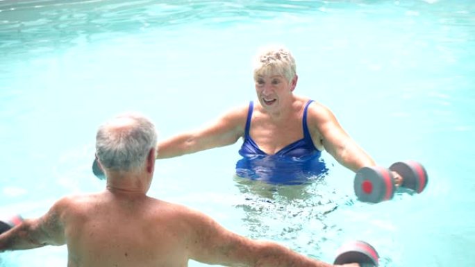高级夫妇在游泳池里做有氧运动