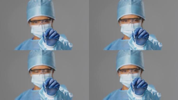 工作室拍摄的女性实验室研究人员戴着PPE和拿着注射器的眼镜进行疫苗接种