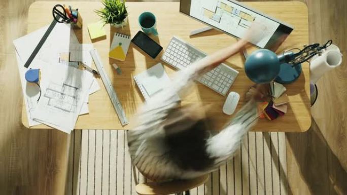 女建筑师在办公桌前忙于纸质蓝图和计算机的俯视图时间流逝