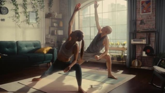 年轻的运动夫妇早上在阳光明媚的家庭客厅锻炼、伸展和练习瑜伽。健康的生活方式、健身、幸福和正念概念。