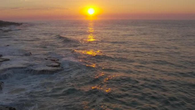 南非东开普省姆坎巴蒂自然保护区崎rock不平的岩石海滩海岸线上的夕阳和海浪的鸟瞰图