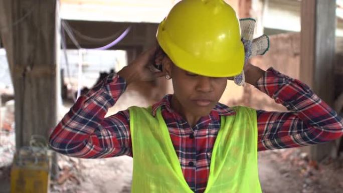 穿着反光背心的非洲女工在建筑工地戴安全帽
