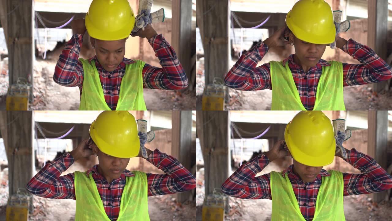 穿着反光背心的非洲女工在建筑工地戴安全帽
