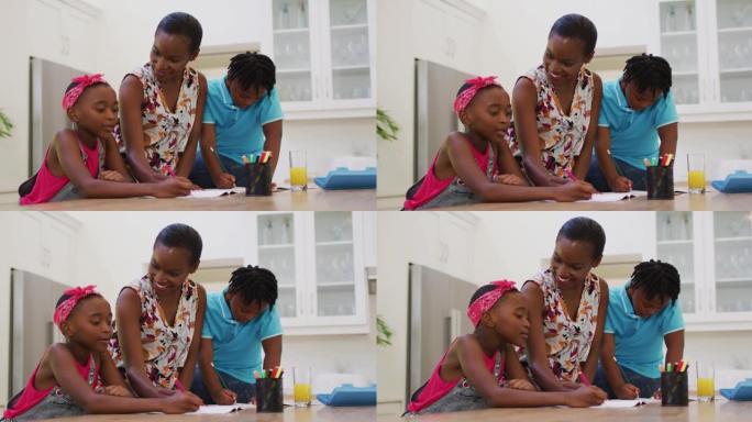 非裔美国母亲在家帮助女儿和儿子做作业