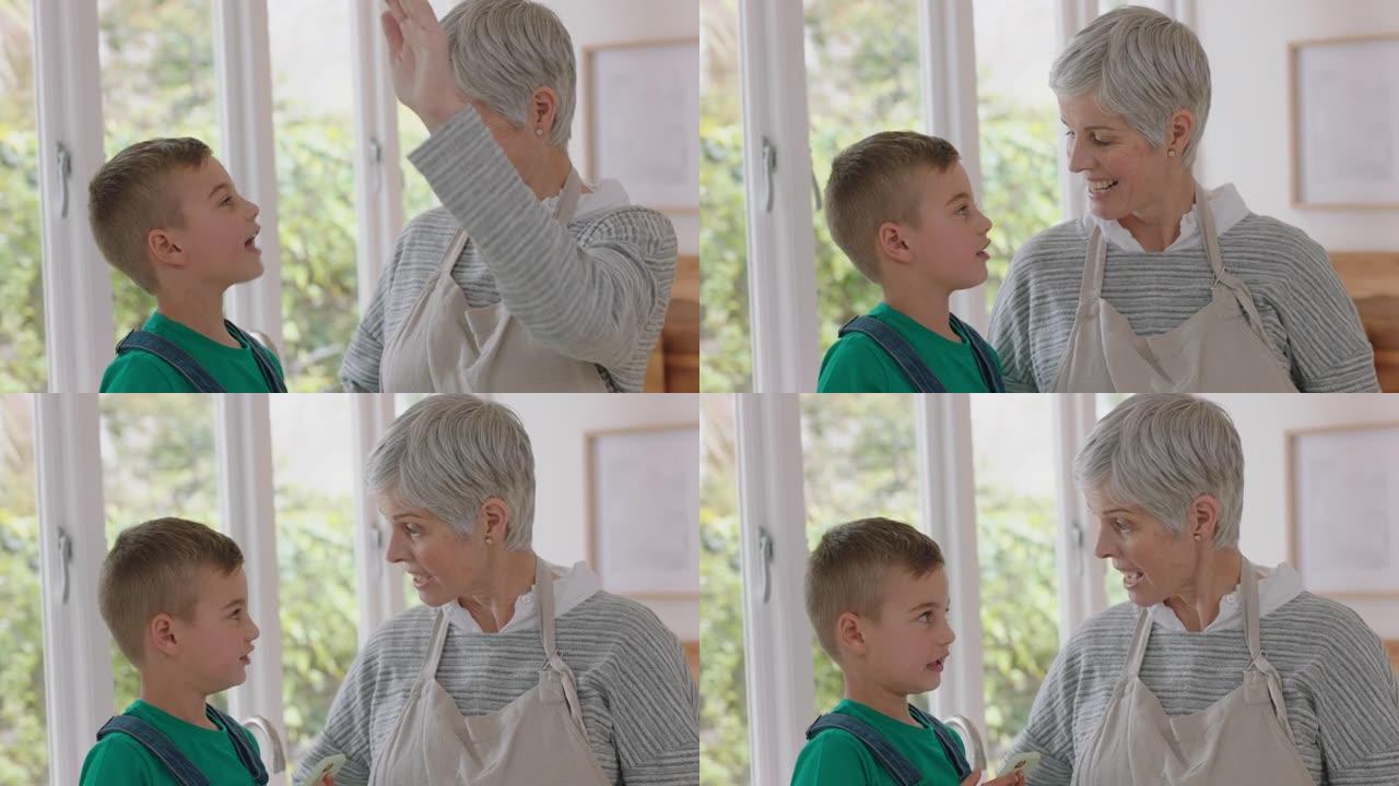 祖母给厨房里的小男孩高五奶奶在家与孙子庆祝团队合作