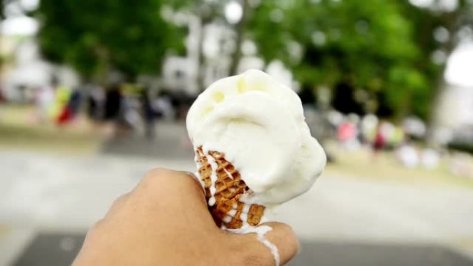 4k视频片段，一名男子拿着融化的冰淇淋蛋筒走来走去