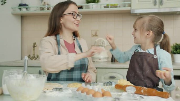 幸福的家庭母女烘烤饼干，在厨房里表达爱的乐趣