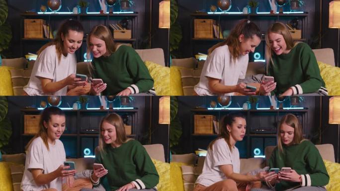 两个快乐的年轻美丽的欧洲朋友使用智能手机在线购物，在舒适的客厅的沙发上大笑。