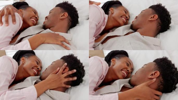 幸福，爱和夫妻在卧室里笑着，在家里一起躺着。年轻的黑人男女在床上放松和休息，在他们的蜜月期间照顾和快
