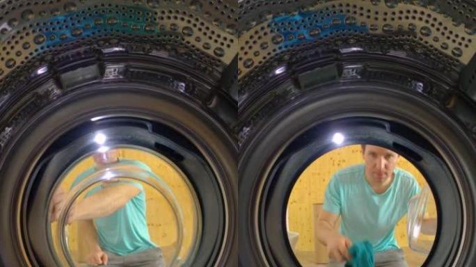 垂直，肖像: 男人把洗衣机装上，看着它洗脏衣服。