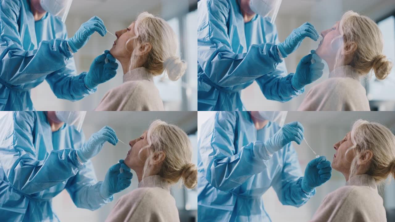 安全手套和口罩，防护面罩和工作服的医护人员正在健康诊所采集PCR电晕病毒样本。医生使用呼吸拭子测试。