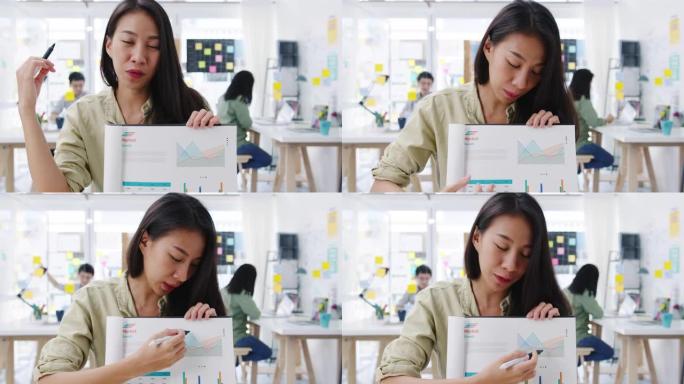 亚洲女商人在新的正常情况下进行社交距离预防病毒在办公室工作时向同事介绍有关视频通话计划的摄像机演示。