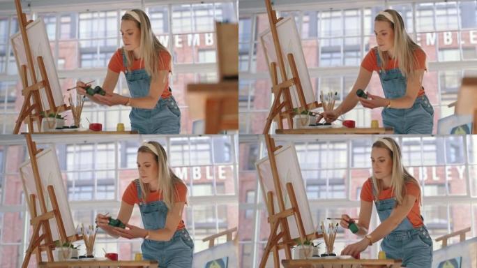 富有创造力的女艺术家在她的家庭艺术工作室绘画时检查油画或丙烯酸漆的颜色。艺术女性准备水彩画并准备在画