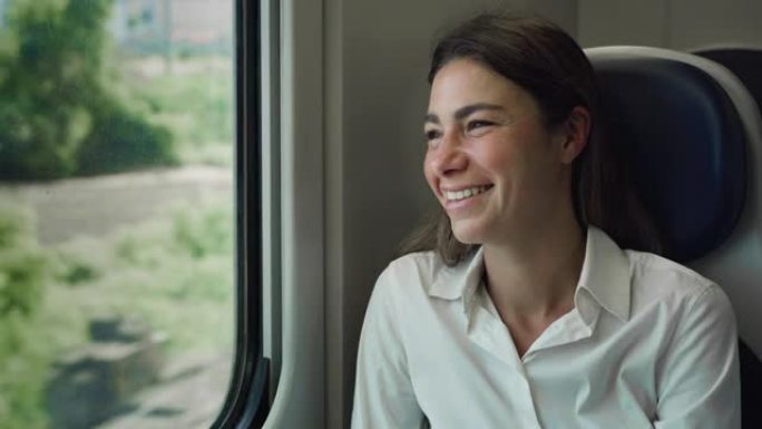 年轻女子乘火车穿越绿色景观时透过窗户看的电影镜头。到达郊区后，快乐的女性微笑着，对新的机会感到兴奋
