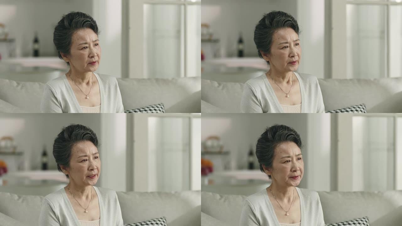 悲伤的亚洲老妇人独自坐在家里