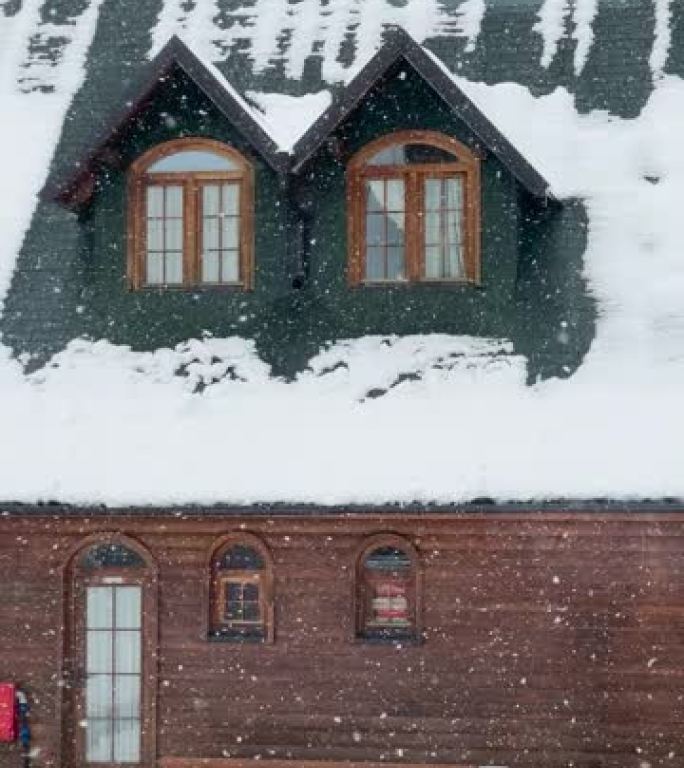 特写: 冬季大雪中带有绿色屋顶的假日山间小屋