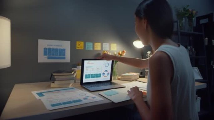 年轻的亚洲商务女士自由职业开放笔记本电脑准备在家庭之夜开始在客厅的木桌上工作。在家工作，远程，为冠状
