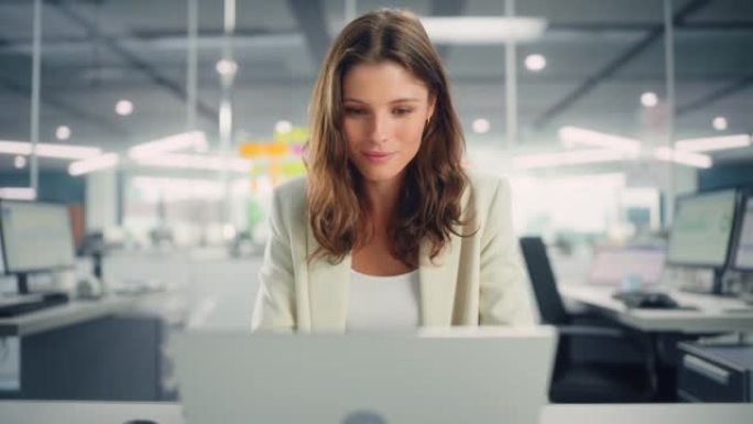 年轻快乐的女商人在现代办公室和同事一起使用电脑。时尚漂亮的经理微笑着，从事商业、金融和营销项目。多元