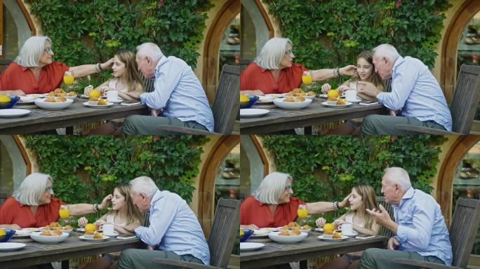 轻松的老年夫妇和孙女一起吃早餐